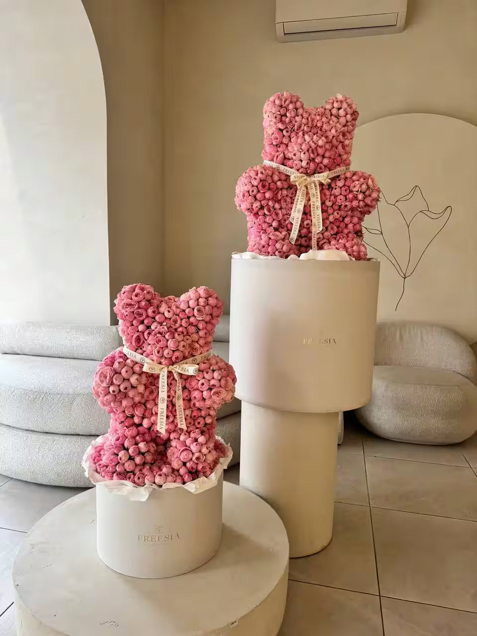 Teddy bear-shaped flower arrangement with pink roses in a modern interior setting