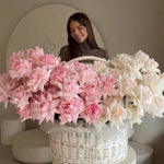 Woman with large basket of fresh pink and white roses in modern floral studio