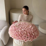Woman with large basket of pink roses in a modern, neutral-toned interior